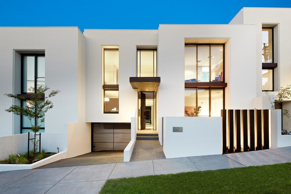 Cette image montre une façade de maison blanche minimaliste à un étage avec un toit plat.