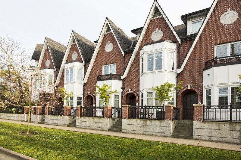 Mittelgroßes, Zweistöckiges Klassisches Reihenhaus mit Backsteinfassade, Satteldach, Schindeldach und brauner Fassadenfarbe in Vancouver