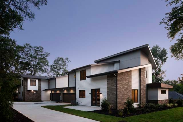 Diseño de fachada blanca moderna de tamaño medio de dos plantas con revestimiento de aglomerado de cemento