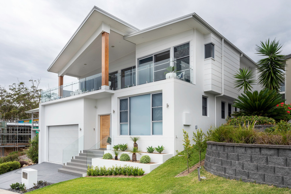 Diseño de fachada de casa blanca marinera de dos plantas con revestimiento de ladrillo y tejado de metal