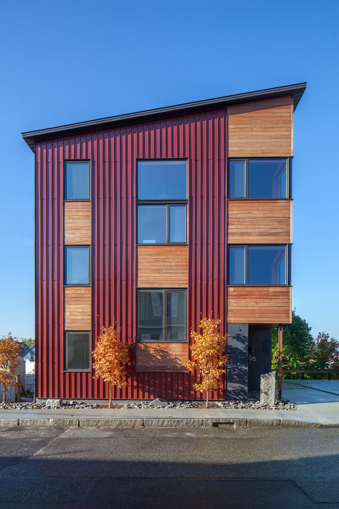 На фото: большой, трехэтажный, разноцветный частный загородный дом в стиле модернизм с комбинированной облицовкой и односкатной крышей с