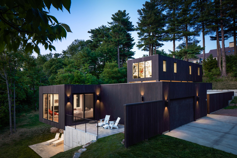 Inspiration for a medium sized and black modern two floor detached house in Burlington with wood cladding and a flat roof.