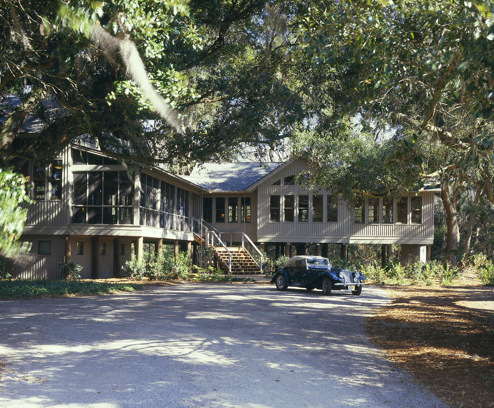 This is an example of a medium sized and gey traditional two floor house exterior in Atlanta with wood cladding and a pitched roof.