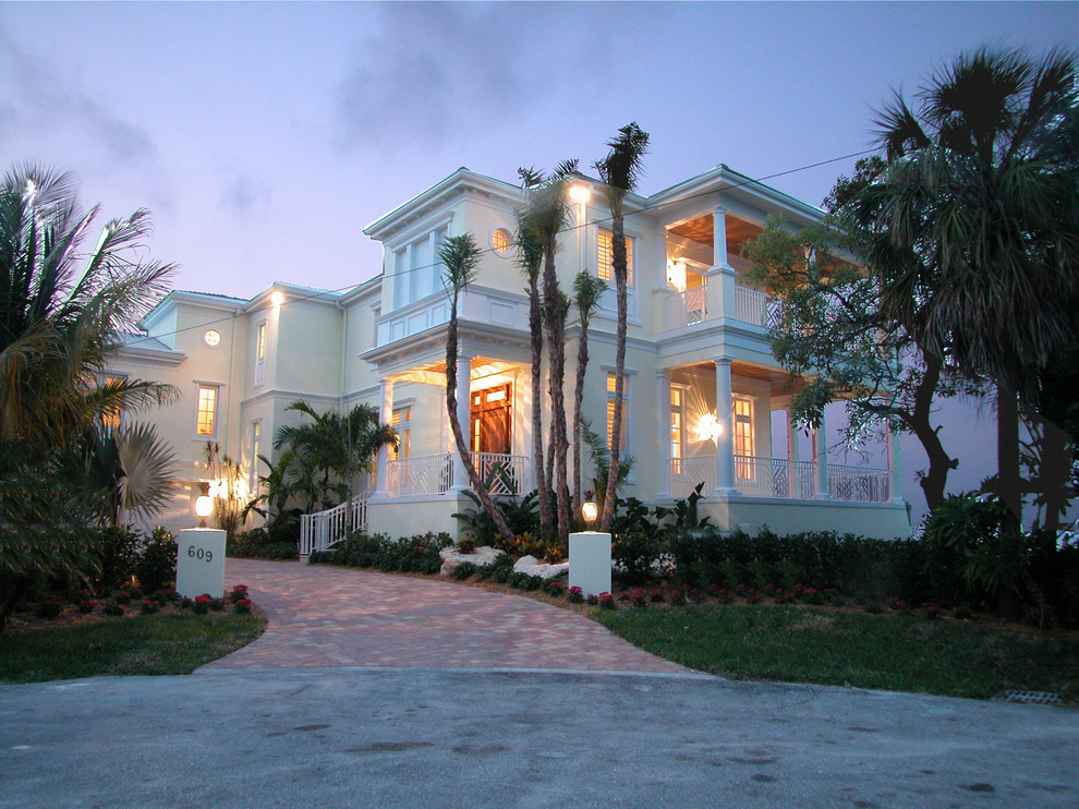 Esempio della facciata di una casa bianca tropicale a due piani di medie dimensioni con rivestimento in stucco