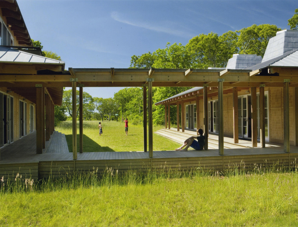 Design ideas for a rustic bungalow house exterior in Boston with wood cladding.