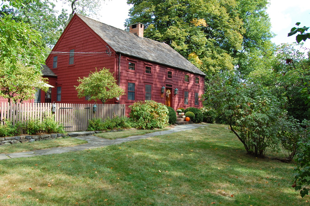 Immagine della facciata di una casa rossa country a due piani con rivestimento in legno e tetto a capanna