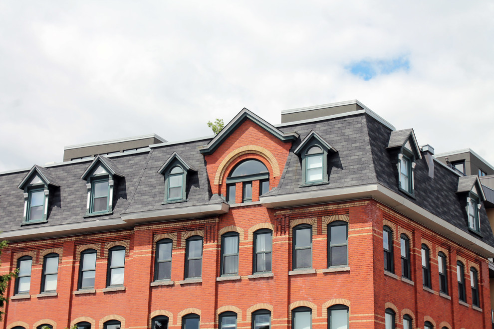 Geräumiges, Dreistöckiges Modernes Haus mit Backsteinfassade, roter Fassadenfarbe und Flachdach in Montreal
