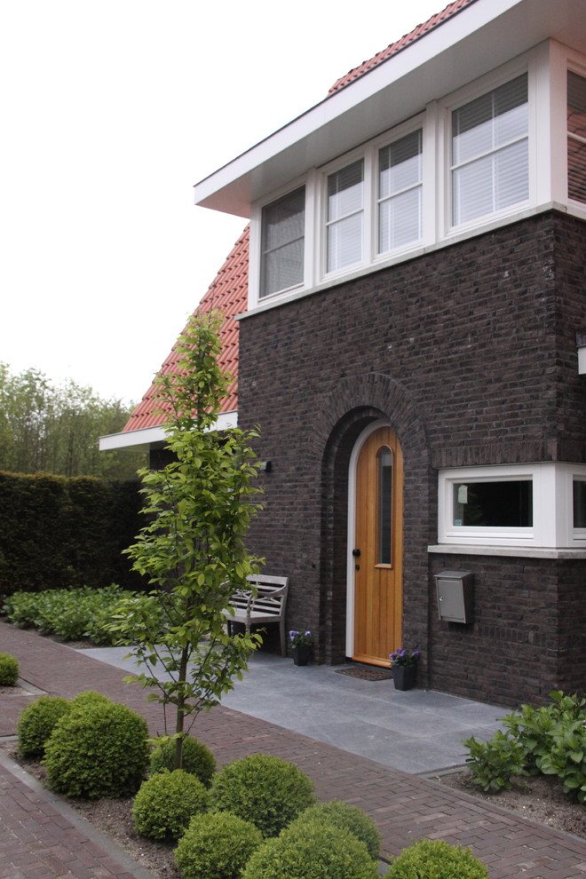 Immagine della facciata di una casa contemporanea con rivestimento in mattoni