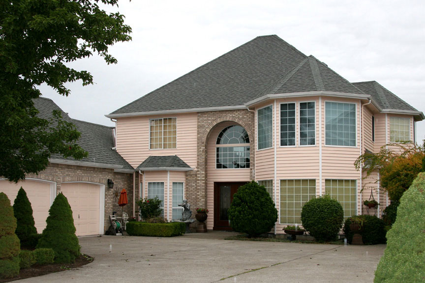 Пример оригинального дизайна: большой, двухэтажный, розовый частный загородный дом в классическом стиле с комбинированной облицовкой, вальмовой крышей и крышей из гибкой черепицы