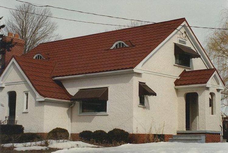 Foto della villa bianca classica a due piani di medie dimensioni con copertura in tegole, rivestimento in stucco e tetto a capanna