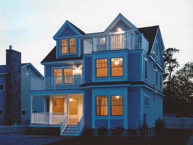 Esempio della facciata di una casa grande blu classica a tre piani con rivestimento in legno e tetto a capanna