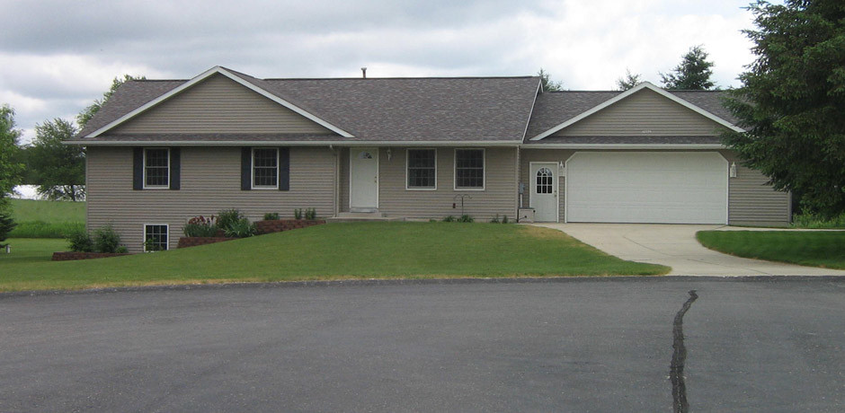 Exemple d'une petite façade de maison grise de plain-pied avec un revêtement mixte et un toit à croupette.