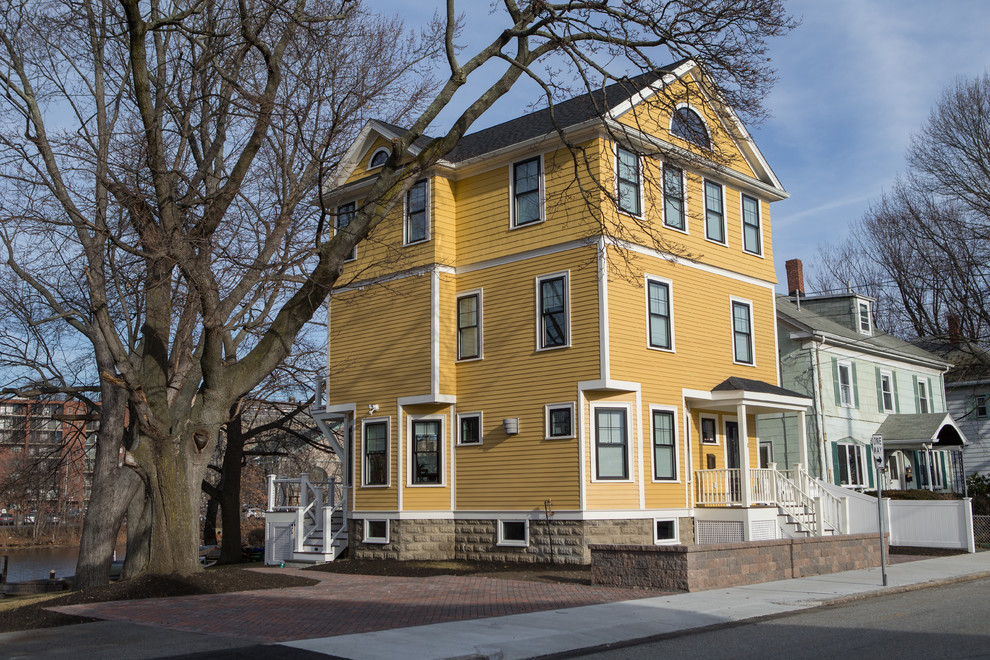 Inspiration for a large transitional yellow three-story wood house exterior remodel in Boston