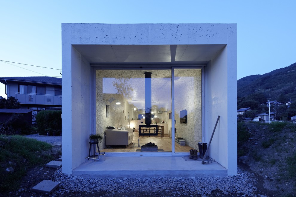 Esempio della facciata di una casa piccola bianca moderna a un piano con rivestimento in cemento e tetto piano