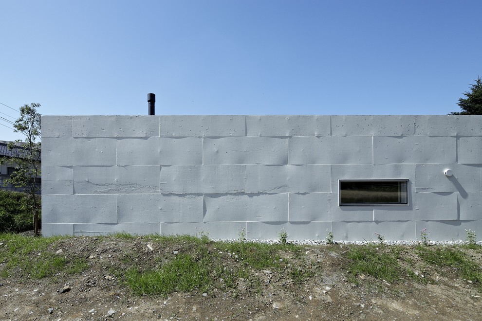 Diseño de fachada blanca minimalista pequeña de una planta con revestimiento de hormigón
