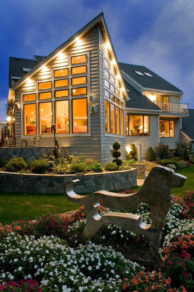 На фото: одноэтажный, серый частный загородный дом среднего размера в современном стиле с облицовкой из винила и крышей из гибкой черепицы