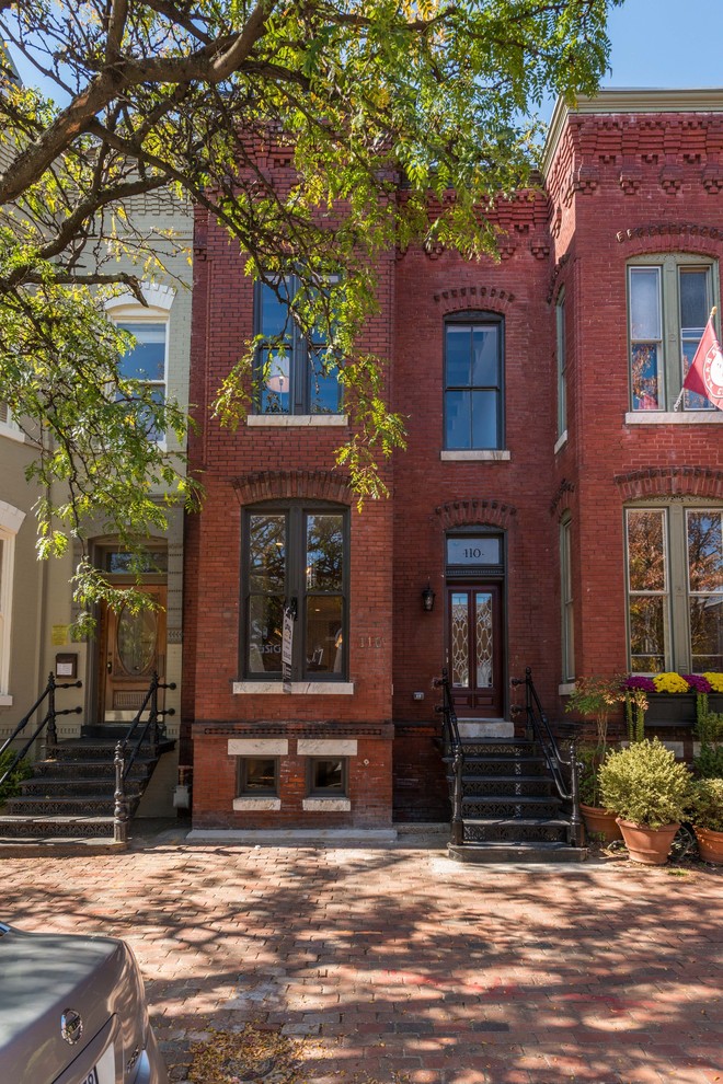 Kleines, Zweistöckiges Klassisches Reihenhaus mit Backsteinfassade, roter Fassadenfarbe und Flachdach in Washington, D.C.