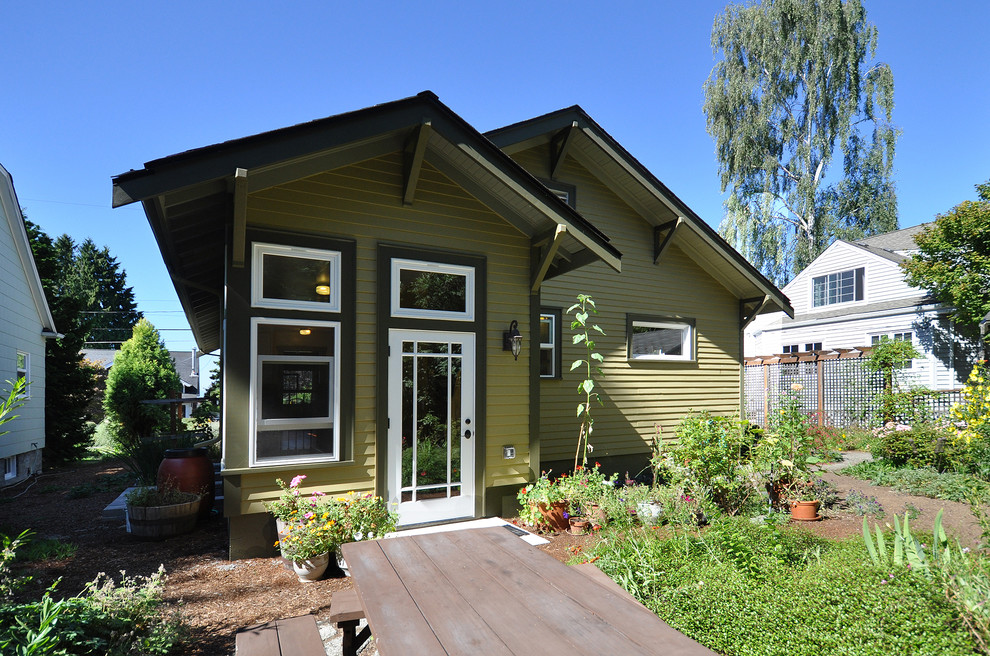 Cette image montre une petite façade de maison verte craftsman en panneau de béton fibré de plain-pied avec un toit à deux pans.