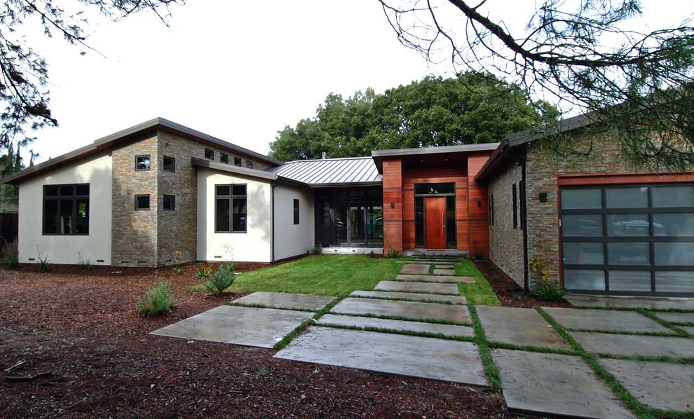 Ejemplo de fachada de casa multicolor minimalista grande de una planta con revestimientos combinados, tejado a dos aguas y tejado de metal