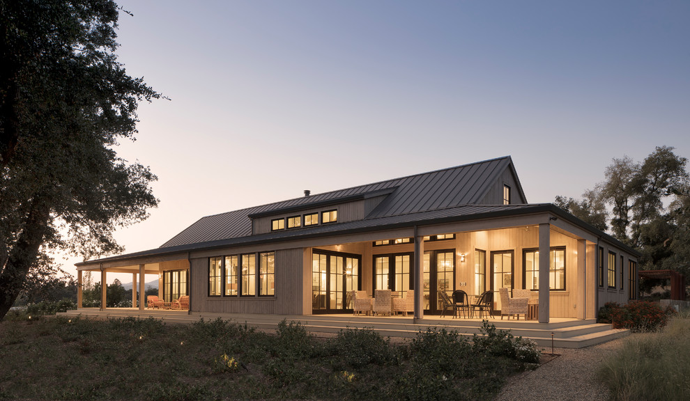 Diseño de fachada de casa gris campestre de una planta con revestimiento de madera, tejado a dos aguas y tejado de metal