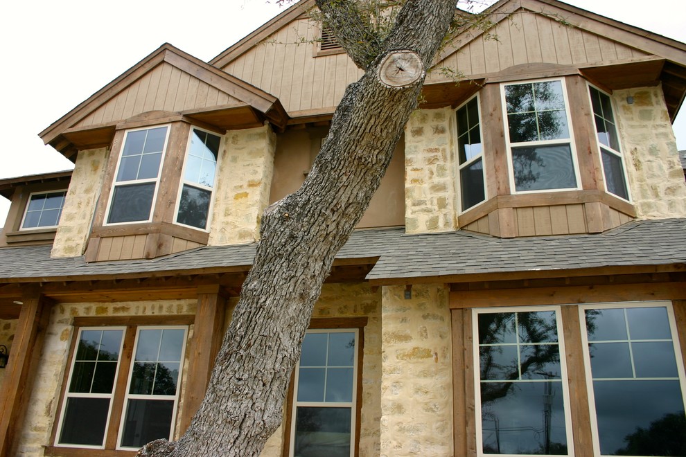 Ejemplo de fachada de casa beige de estilo de casa de campo grande de dos plantas con revestimientos combinados, tejado a dos aguas y tejado de teja de madera