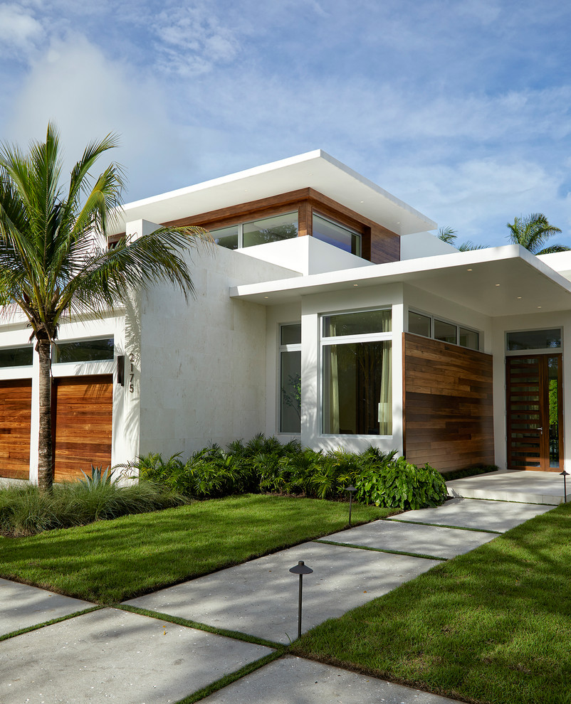 На фото: двухэтажный, большой, белый частный загородный дом в стиле модернизм с плоской крышей, облицовкой из цементной штукатурки и зеленой крышей с