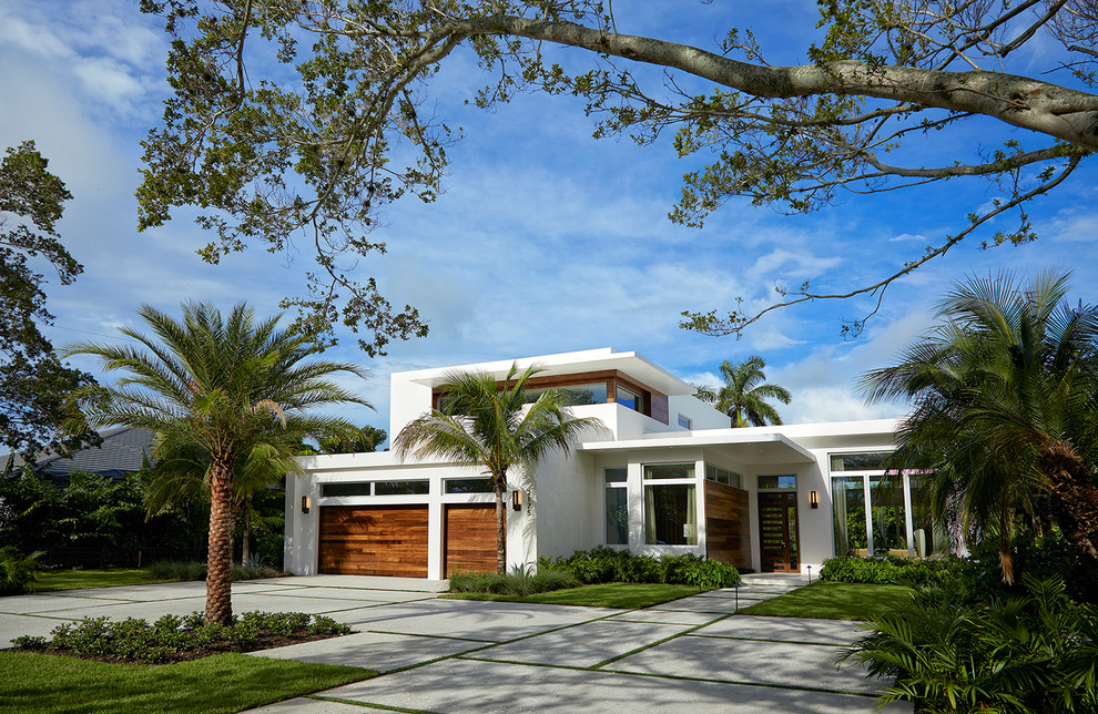Стильный дизайн: двухэтажный, большой, белый частный загородный дом в стиле модернизм с плоской крышей, облицовкой из цементной штукатурки и зеленой крышей - последний тренд