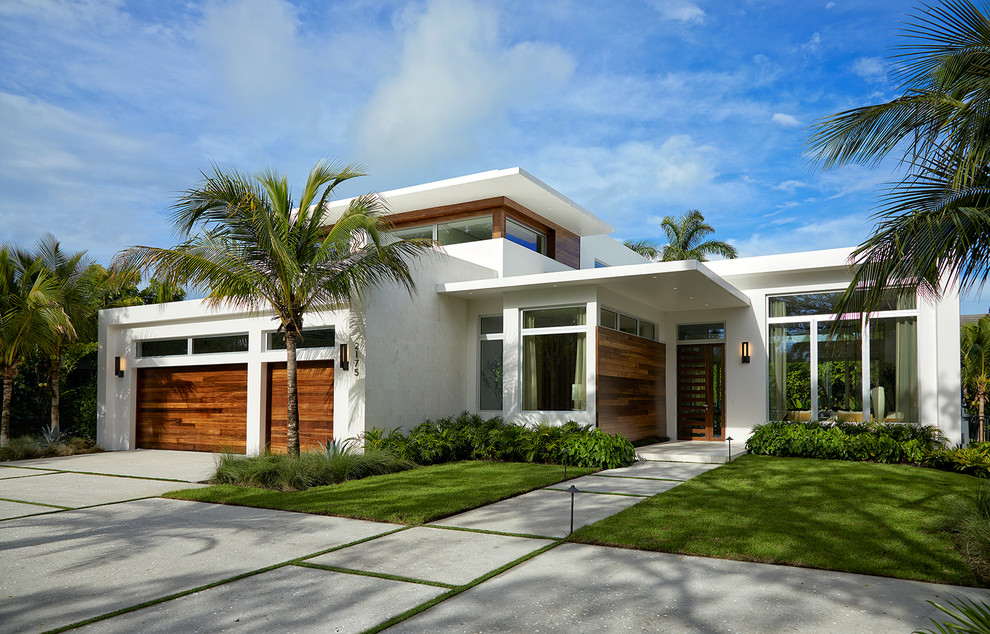 На фото: двухэтажный, большой, белый частный загородный дом в стиле модернизм с плоской крышей, облицовкой из цементной штукатурки и зеленой крышей