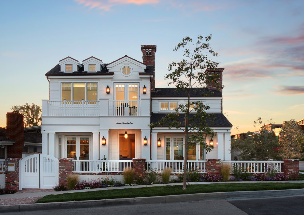 Immagine della facciata di una casa bianca stile marinaro a due piani con rivestimento in legno