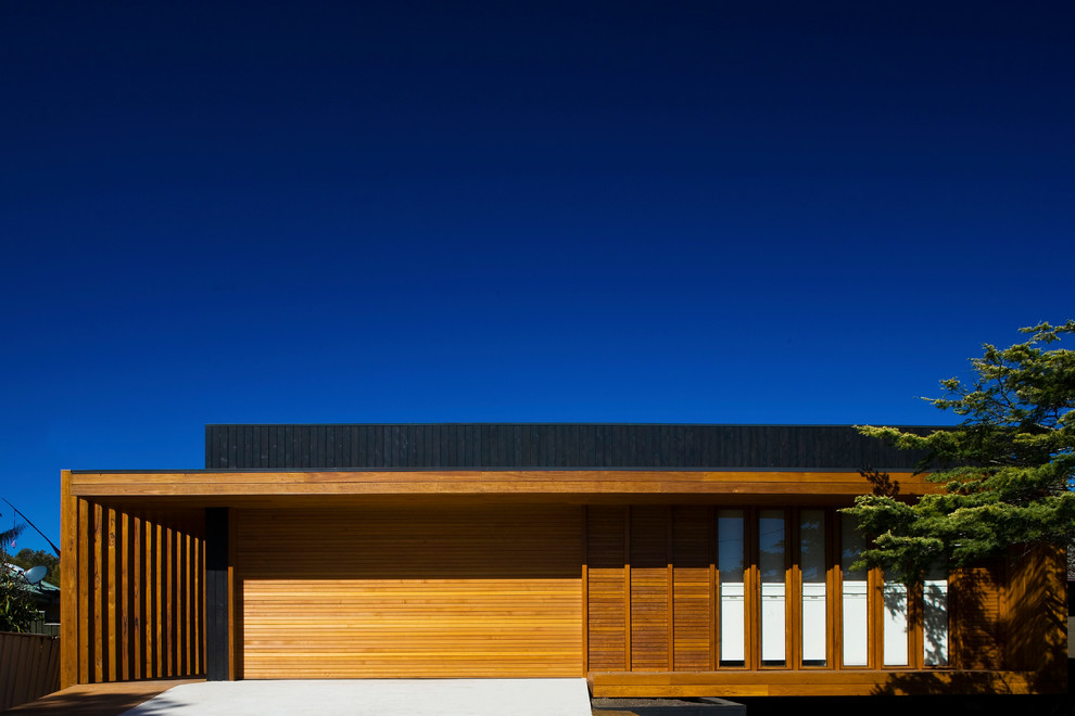 Immagine della villa grande marrone contemporanea a due piani con rivestimento in legno, tetto piano e copertura in metallo o lamiera