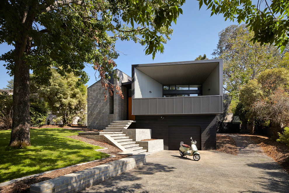Réalisation d'une façade de maison grise design à un étage avec un toit plat.