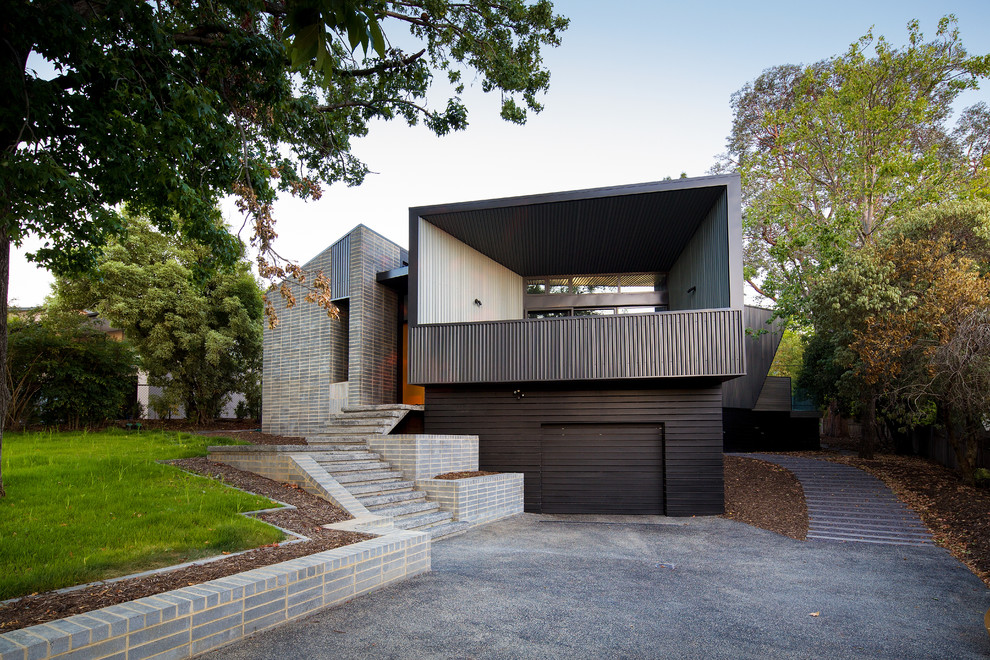 Идея дизайна: большой, двухэтажный, коричневый дом в современном стиле с комбинированной облицовкой и плоской крышей