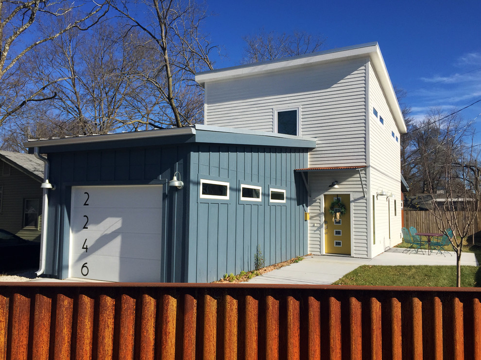 This is an example of a medium sized contemporary two floor detached house in Kansas City with a flat roof and a metal roof.