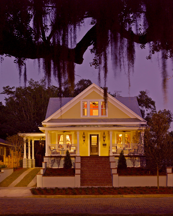 Esempio della facciata di una casa gialla american style a due piani di medie dimensioni con rivestimento in vinile e falda a timpano