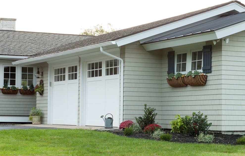 Modelo de fachada de casa gris costera de tamaño medio de una planta con revestimiento de madera, tejado a dos aguas y tejado de metal