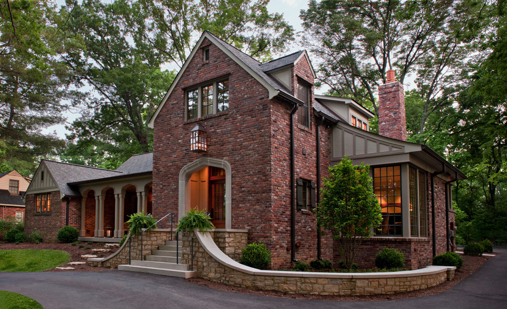 Inspiration for a large timeless red two-story brick exterior home remodel in Nashville with a gambrel roof