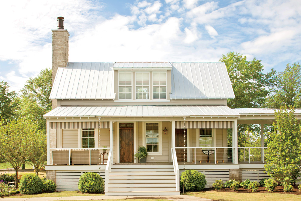 Immagine della facciata di una casa grande beige country a due piani con rivestimento in legno e tetto a padiglione