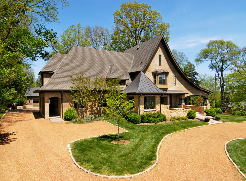 Cette photo montre une grande façade de maison beige chic en pierre à deux étages et plus avec un toit à croupette.