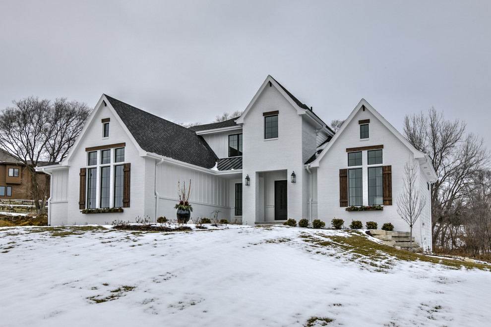 Mittelgroßes, Zweistöckiges Country Einfamilienhaus mit Putzfassade, weißer Fassadenfarbe, Satteldach und Schindeldach in Omaha