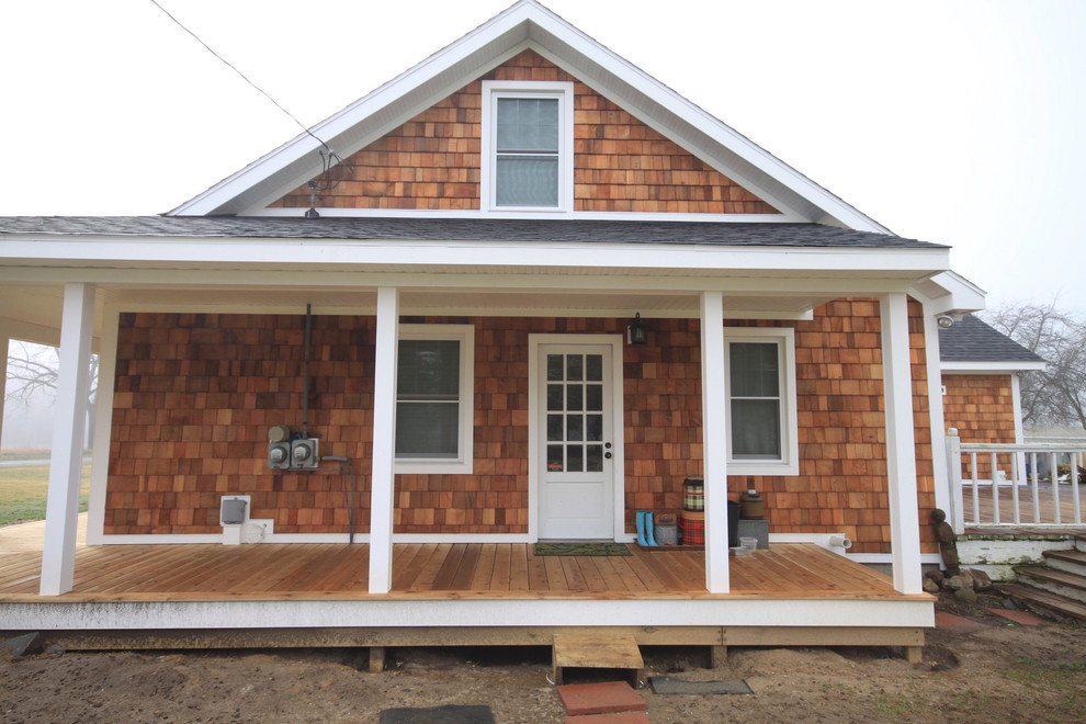 Immagine della facciata di una casa piccola country a un piano con rivestimento in legno