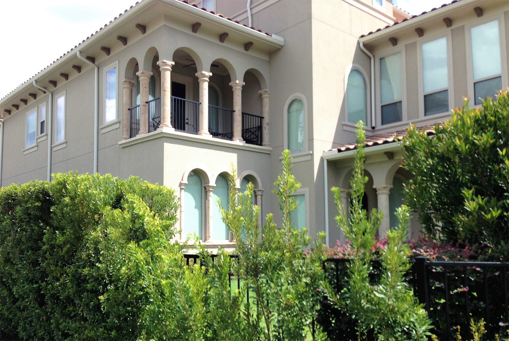 Diseño de fachada de casa beige mediterránea de tamaño medio de dos plantas con revestimiento de estuco