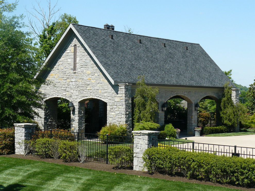 Стильный дизайн: большой, серый, двухэтажный частный загородный дом в стиле кантри с облицовкой из камня, полувальмовой крышей и крышей из гибкой черепицы - последний тренд