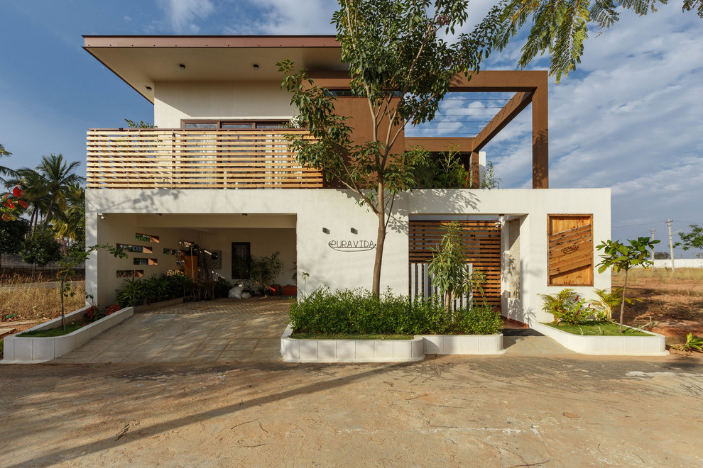 Diseño de fachada de casa multicolor moderna de dos plantas con revestimiento de estuco y tejado plano