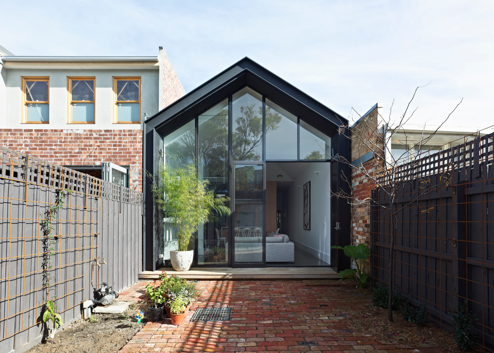 Свежая идея для дизайна: маленький, одноэтажный, черный дом в современном стиле с полувальмовой крышей для на участке и в саду - отличное фото интерьера