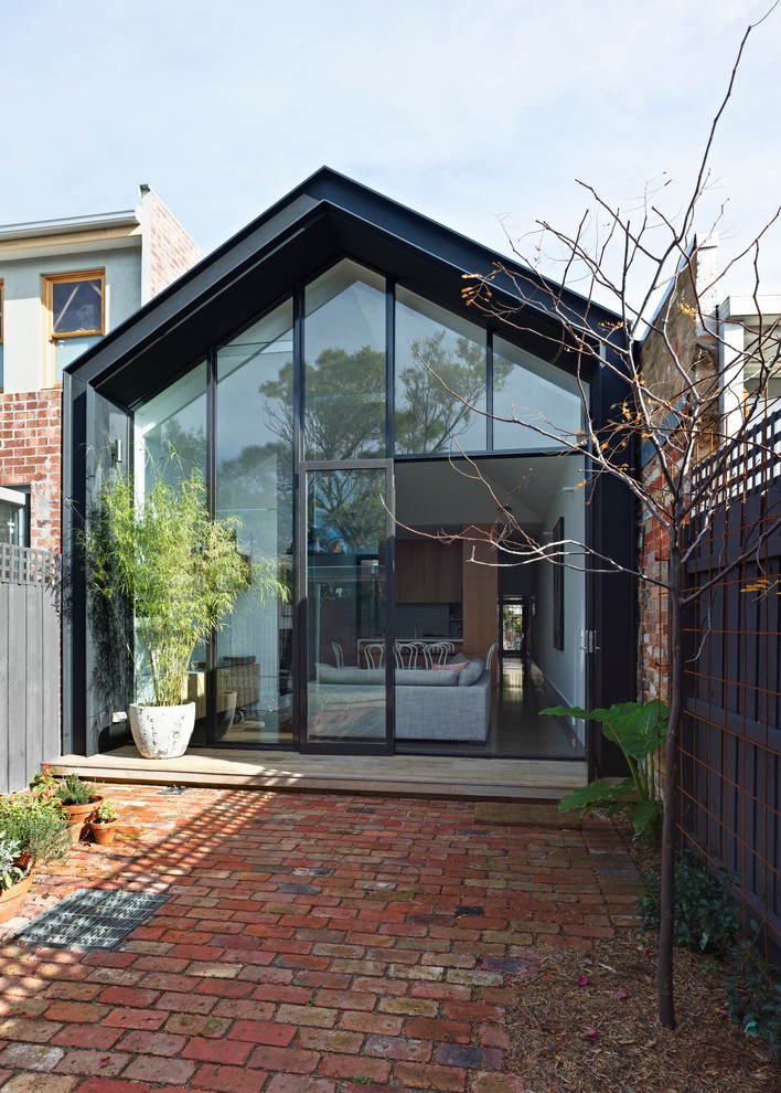 Идея дизайна: маленький, одноэтажный, черный дом в современном стиле с полувальмовой крышей для на участке и в саду