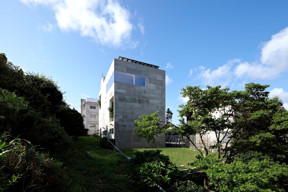 Modelo de fachada gris contemporánea de tamaño medio de tres plantas con revestimiento de hormigón