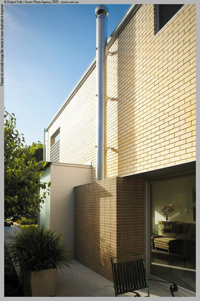 Idee per la facciata di una casa beige a due piani con rivestimento in mattoni