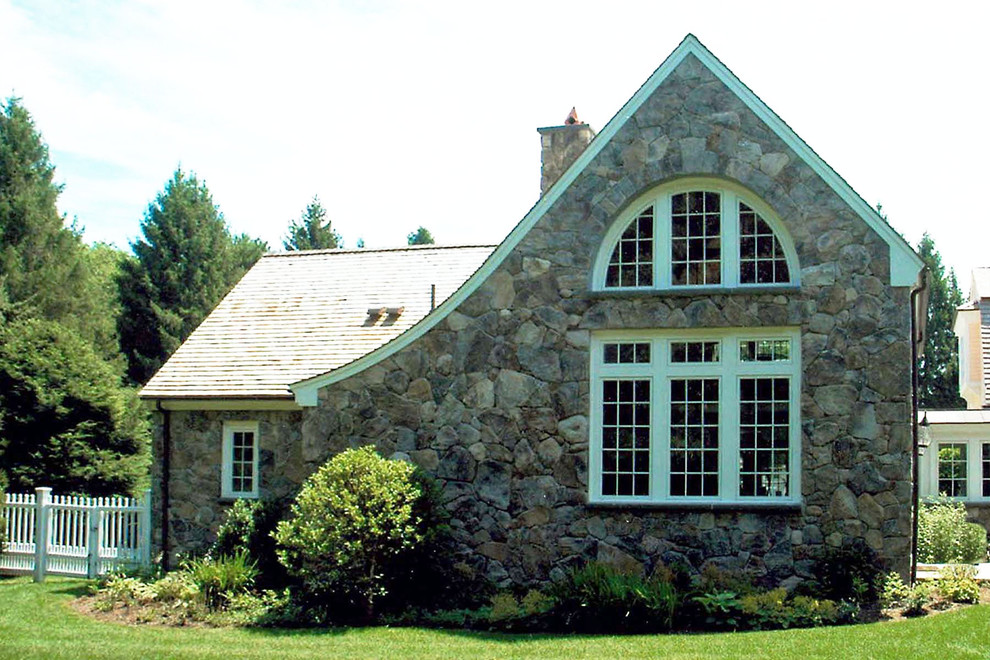 Exemple d'une façade de maison chic en pierre à un étage avec un toit à deux pans et un toit en shingle.