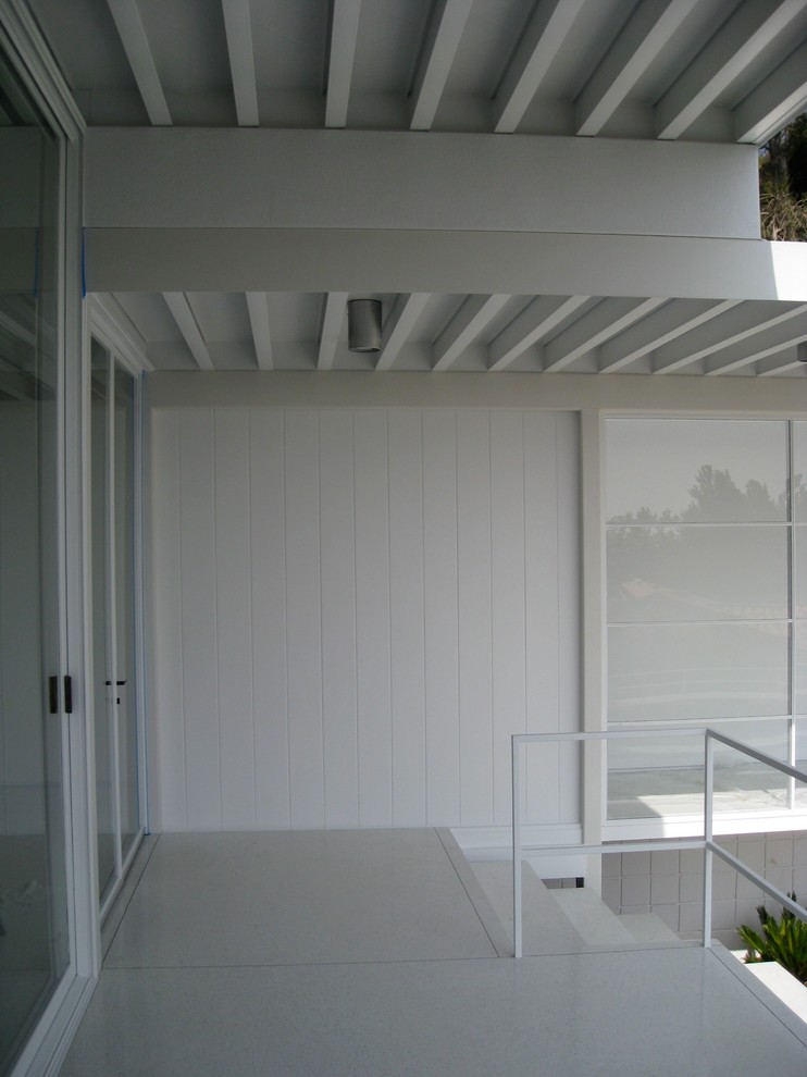 Foto de fachada de casa blanca retro grande de una planta con tejado plano y revestimiento de estuco