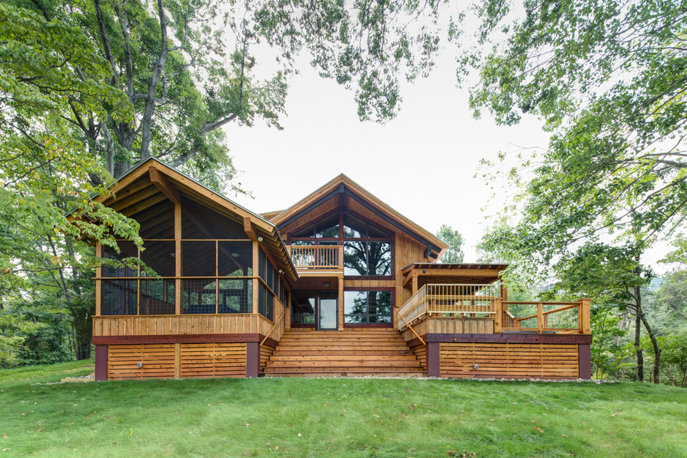 Пример оригинального дизайна: двухэтажный, деревянный, коричневый дом в стиле рустика с двускатной крышей